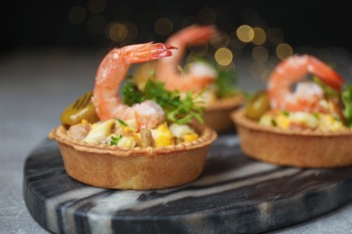 Photo of Tartlets with delicious filling on table, closeup. Bokeh effect