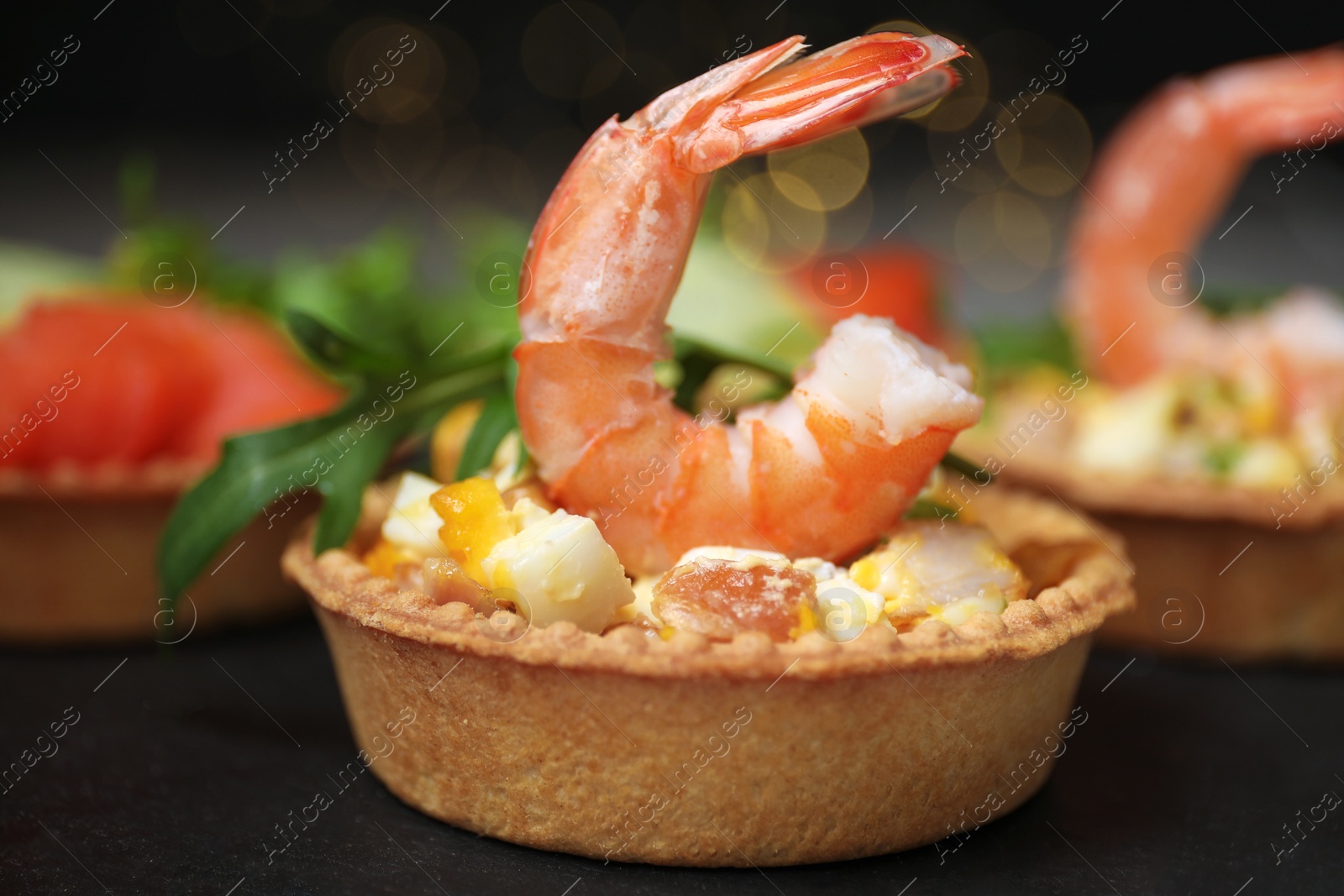 Photo of Tartlets with delicious fillings on table, closeup. Bokeh effect