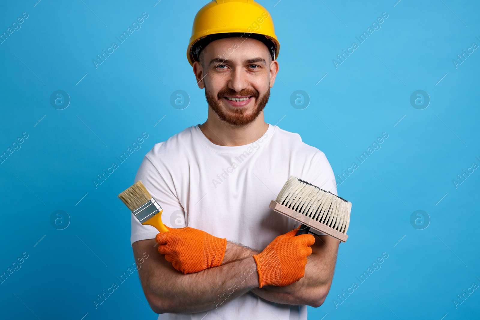 Photo of Man wearing hardhat with tools on blue background