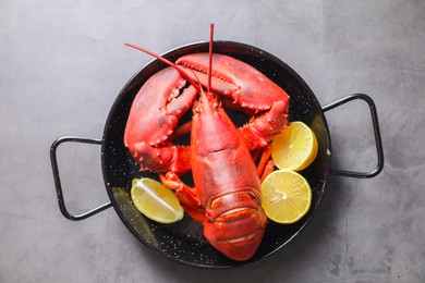 Photo of Delicious boiled lobster with lemon pieces on grey table, top view