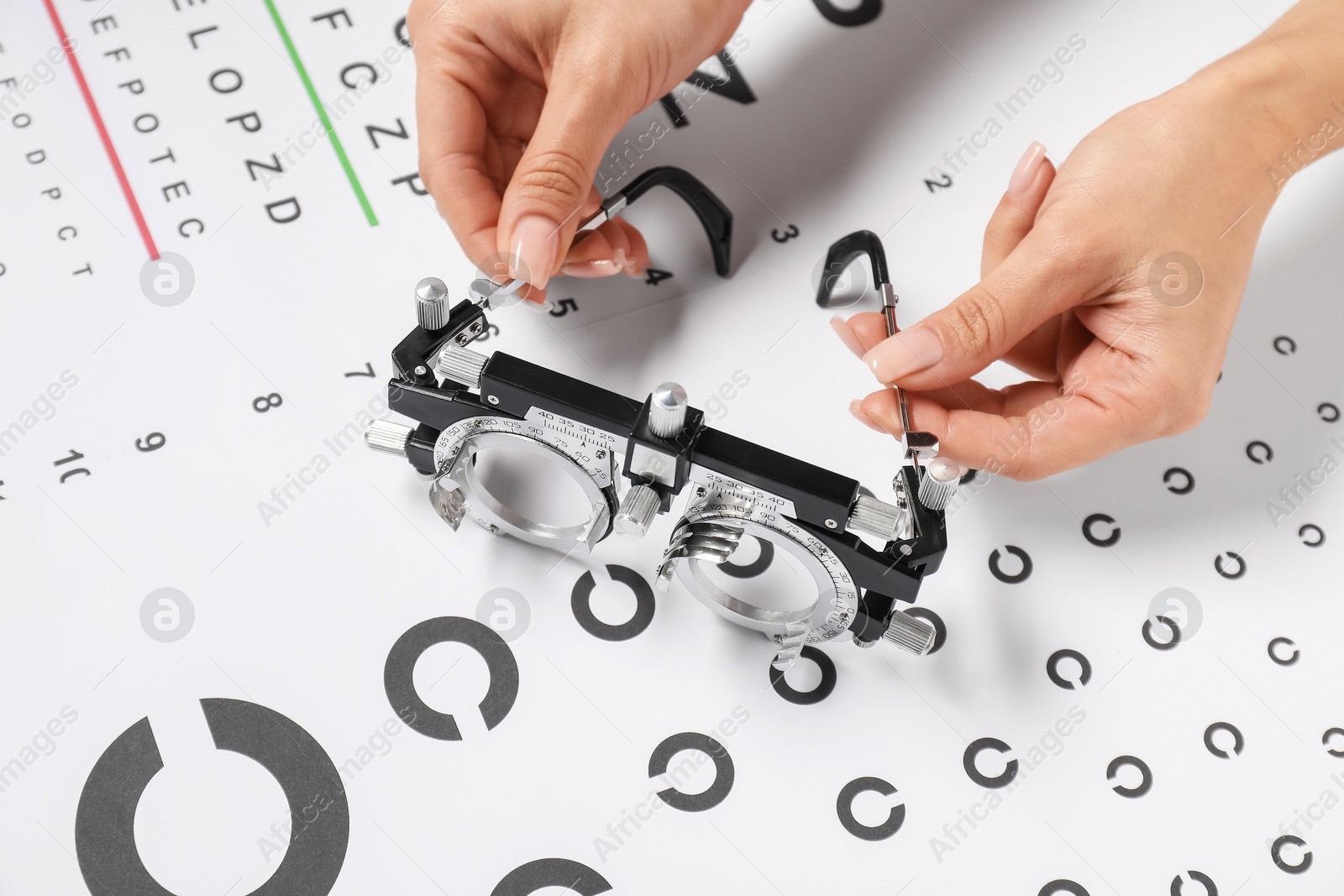 Photo of Woman with trial frame and vision test chart, closeup