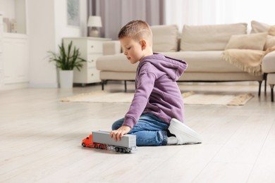 Photo of Little boy playing with toy car at home