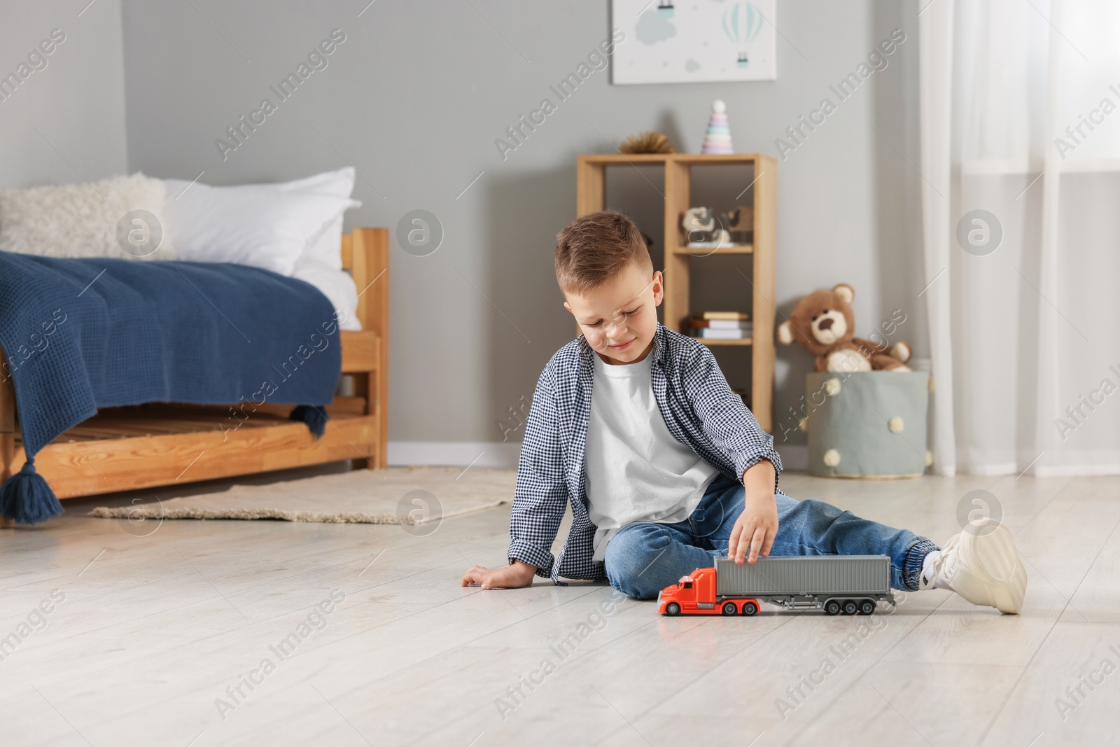 Photo of Little boy playing with toy car at home