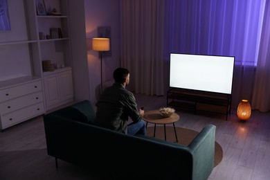 Man watching tv at home in evening