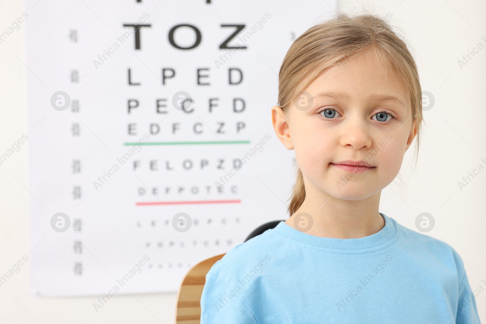 Photo of Little girl against vision test chart. Eye examination