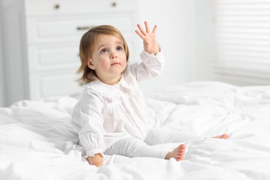 Photo of Cute little baby girl on bed at home