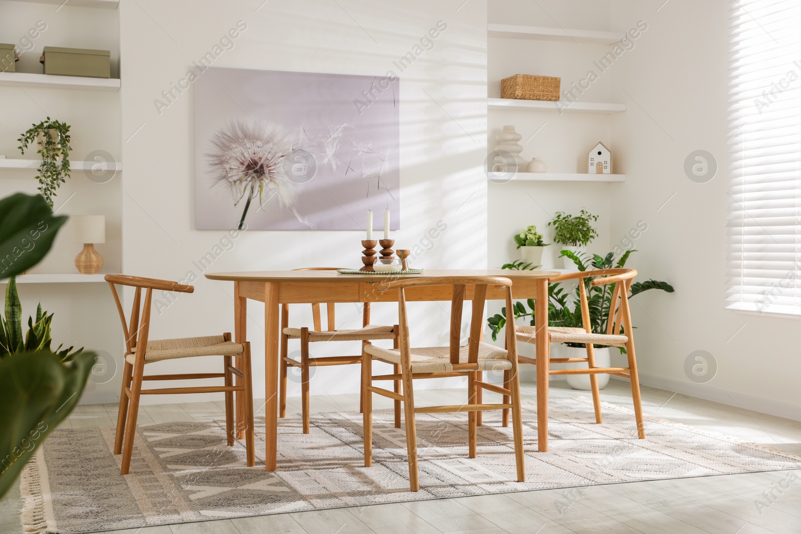 Photo of Stylish room with wooden table, chairs and houseplants. Interior design