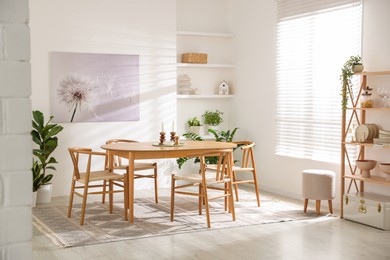 Stylish room with wooden table, chairs and houseplants. Interior design