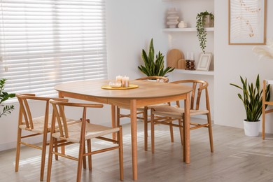 Photo of Stylish wooden table with chairs and decor indoors. Interior design