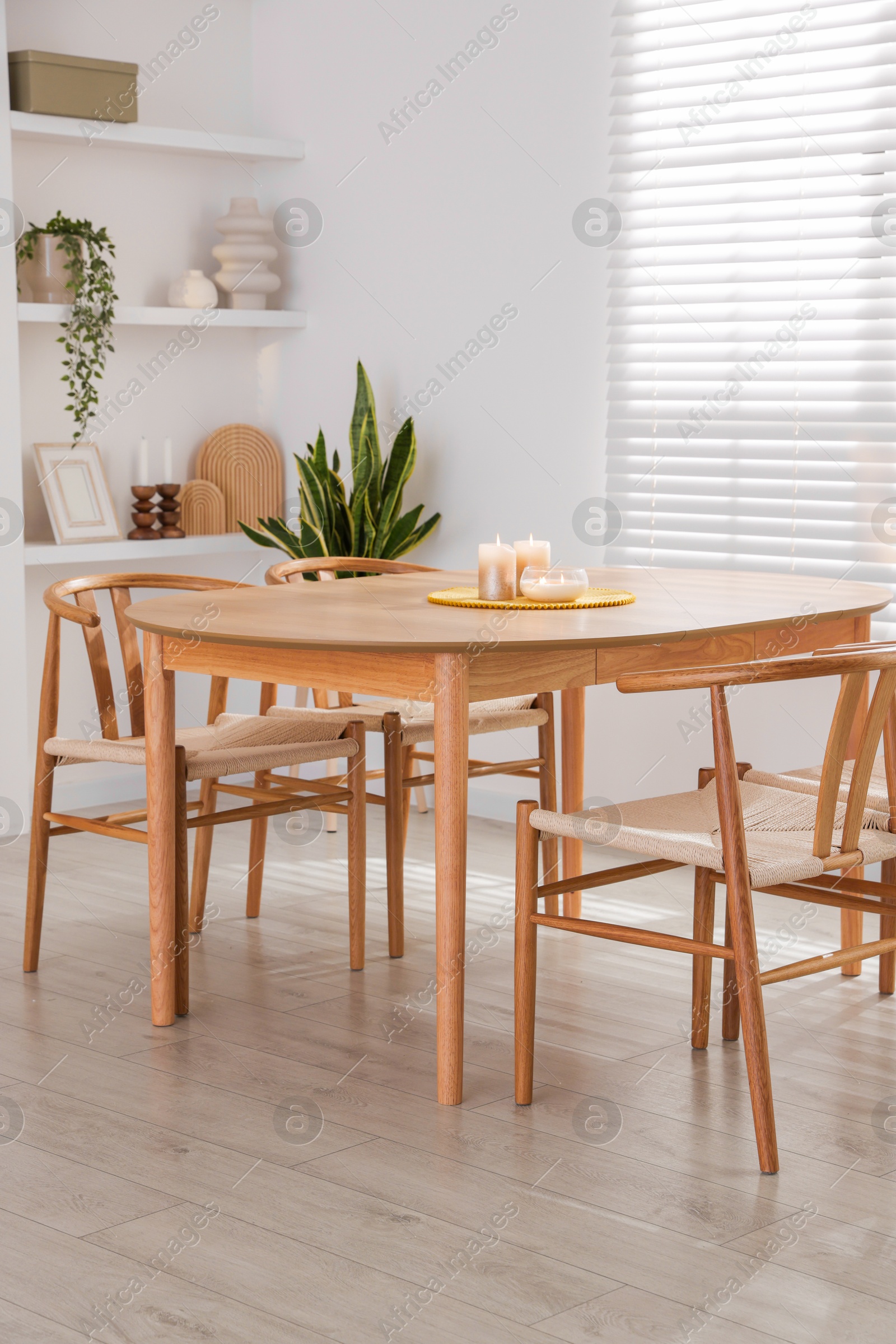 Photo of Stylish wooden table with chairs and decor indoors. Interior design