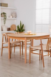 Photo of Stylish wooden table with chairs and decor indoors. Interior design