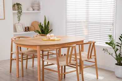 Photo of Stylish wooden table with chairs and decor indoors. Interior design