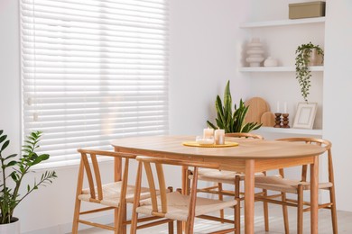 Photo of Stylish wooden table with chairs and decor indoors. Interior design