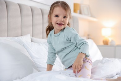 Cute little girl on bed at home