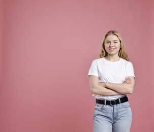 Photo of Smiling woman in stylish jeans on pink background. Space for text