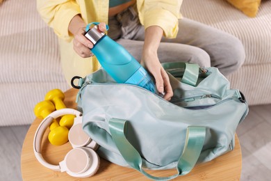 Woman packing her gym bag at home, closeup