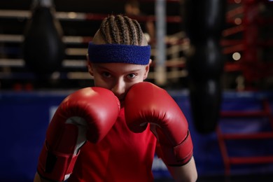 Photo of Boxing. Boy in protective gloves at training center