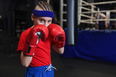 Photo of Boxing. Boy in protective gloves at training center. Space for text