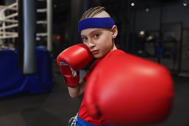 Boxing. Boy in protective gloves at training center