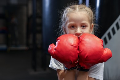 Photo of Boxing. Girl in protective gloves at training center. Space for text