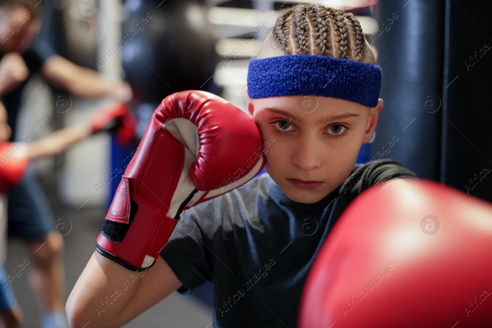 Photo of Boy in protective gloves during boxing practice at training center