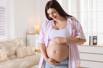 Photo of Beautiful pregnant woman with cute belly at home