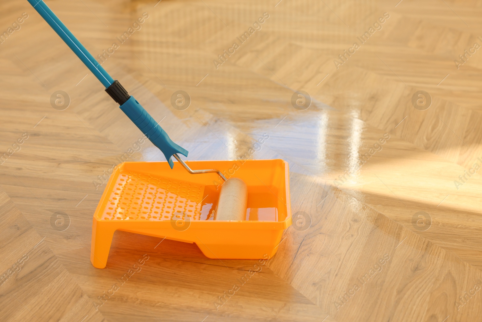 Photo of Process of polishing. Roller and tray with varnish on floor, space for text