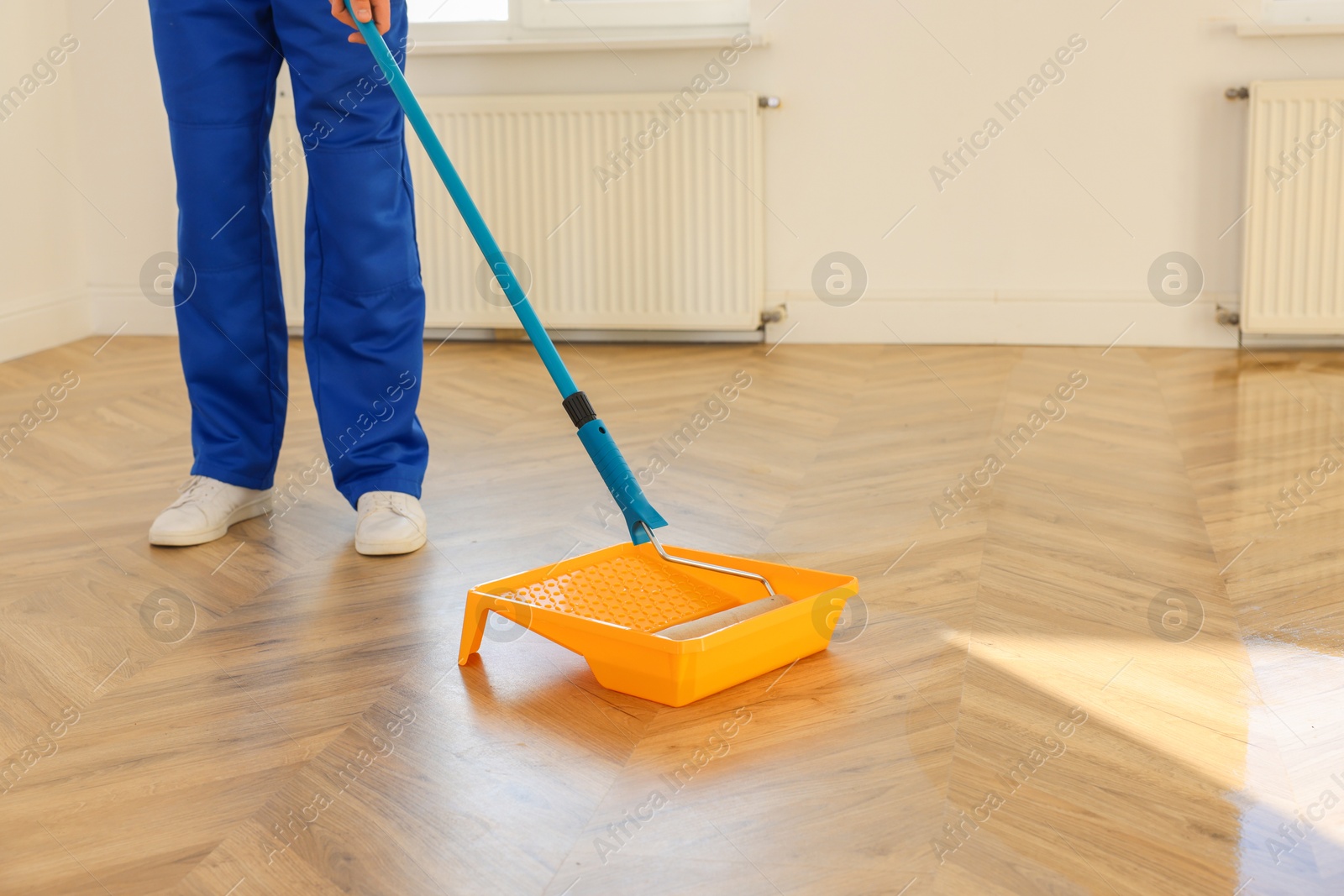 Photo of Process of polishing. Man dipping roller into tray with varnish indoors, closeup. Space for text