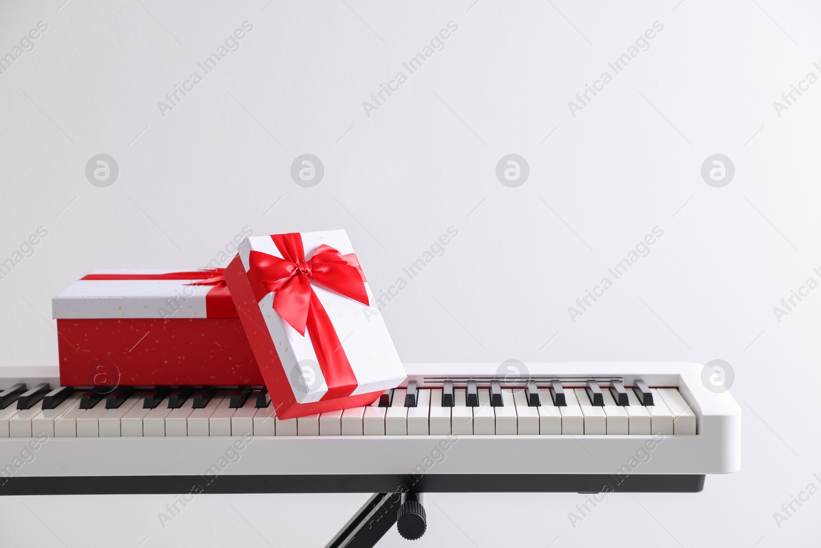 Christmas gifts on synthesizer against white background Photo of Christmas gifts on synthesizer against white background