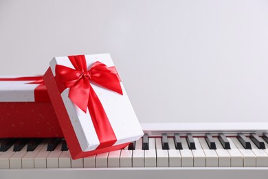 Photo of Christmas gifts on synthesizer against white background, closeup. Space for text