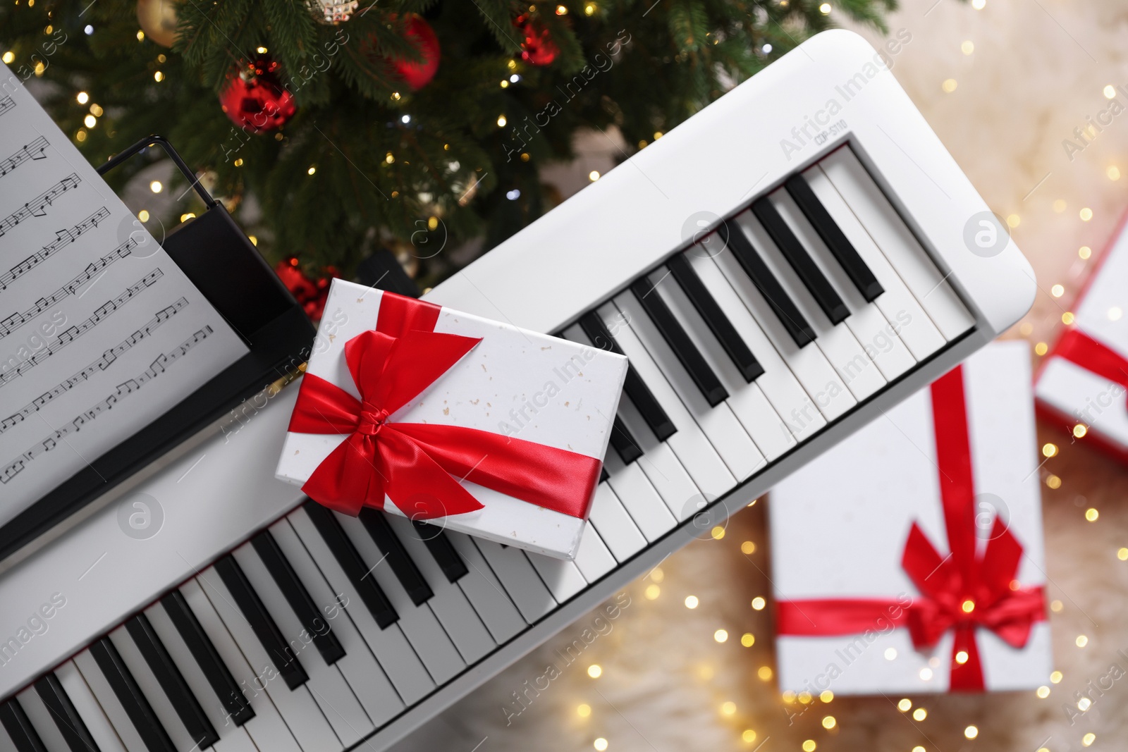 Synthesizer with gift boxes near Christmas tree indoors, top view Photo of Synthesizer with gift boxes near Christmas tree indoors, top view