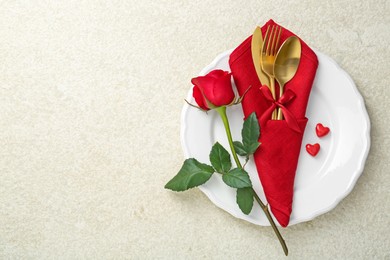 Photo of Romantic place setting with red rose on white table, top view. Valentine's day celebration