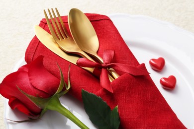 Romantic place setting with red rose on white table, closeup. Valentine's day celebration