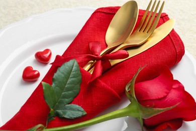 Romantic place setting with red rose on white table, closeup. Valentine's day celebration