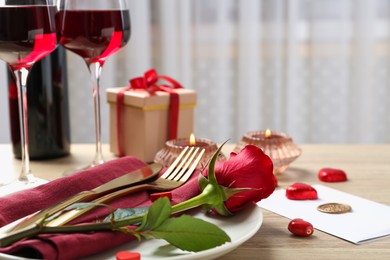 Romantic place setting with red rose on table, closeup. Valentine's day celebration