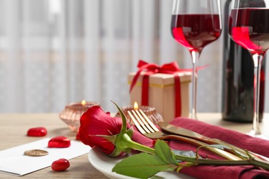 Romantic place setting with red rose on table, closeup. Valentine's day celebration