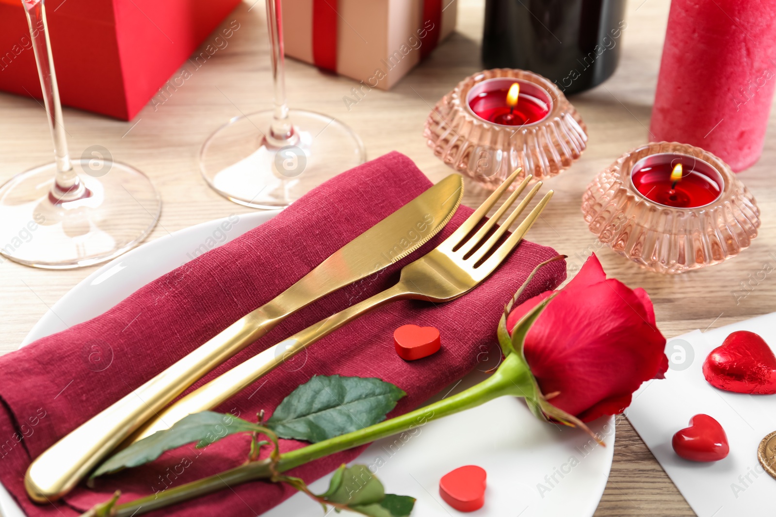 Photo of Romantic place setting with red rose on white table, closeup. Valentine's day celebration