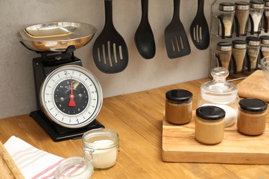 Photo of Retro mechanical kitchen scale and food products on wooden countertop indoors