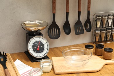 Photo of Retro mechanical kitchen scale and food products on wooden countertop indoors