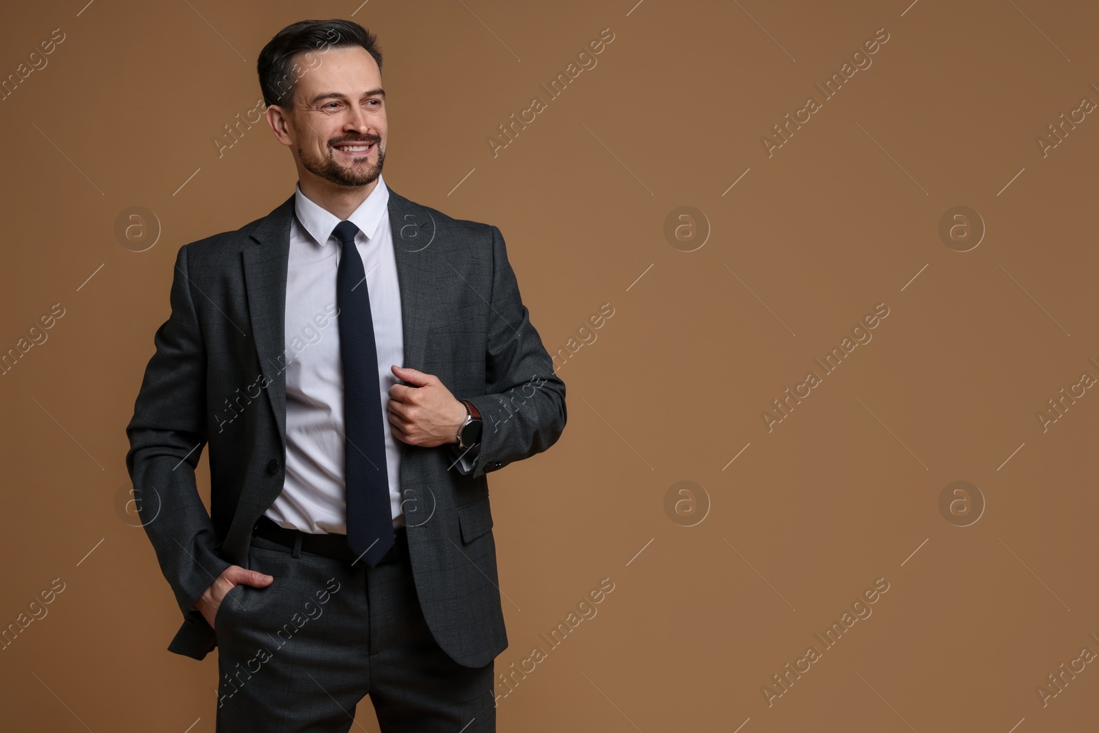 Photo of Handsome man in classic suit on brown background. Space for text