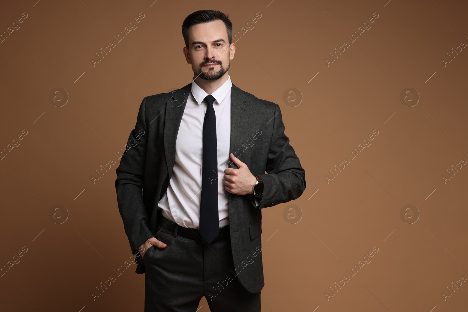 Photo of Handsome man in classic suit on brown background. Space for text