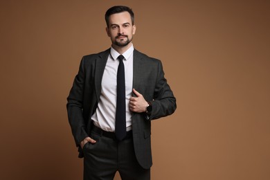 Photo of Handsome man in classic suit on brown background. Space for text