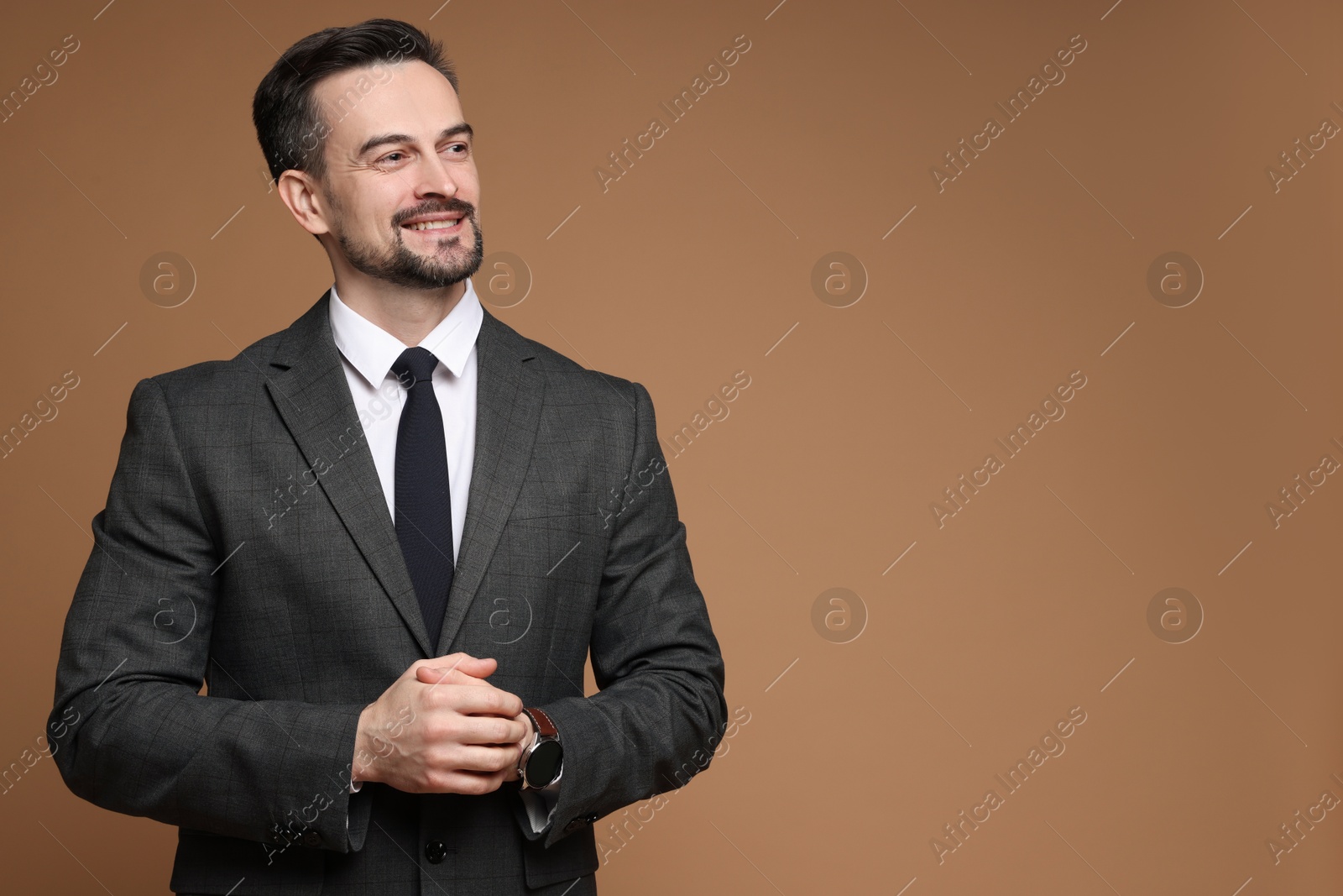 Photo of Handsome man in classic suit on brown background. Space for text