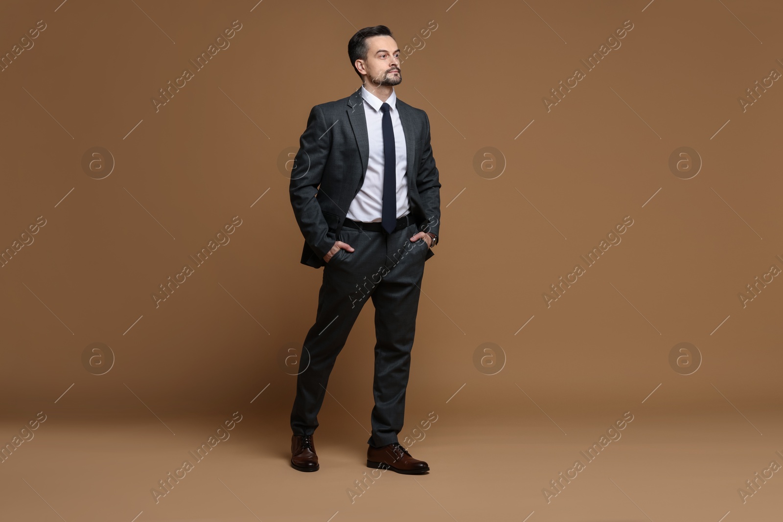 Photo of Confident man in classic suit on brown background