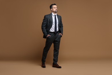 Photo of Confident man in classic suit on brown background