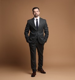 Photo of Confident man in classic suit on brown background