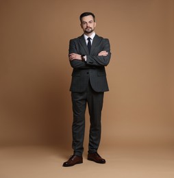 Photo of Confident man in classic suit on brown background