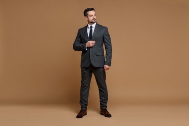 Confident man in classic suit on brown background