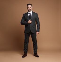 Photo of Confident man in classic suit on brown background