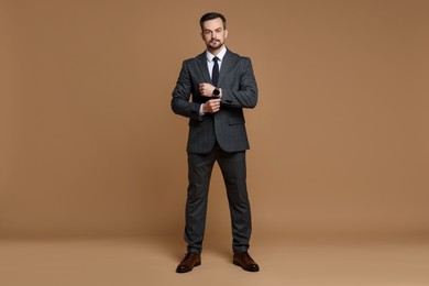 Confident man in classic suit on brown background